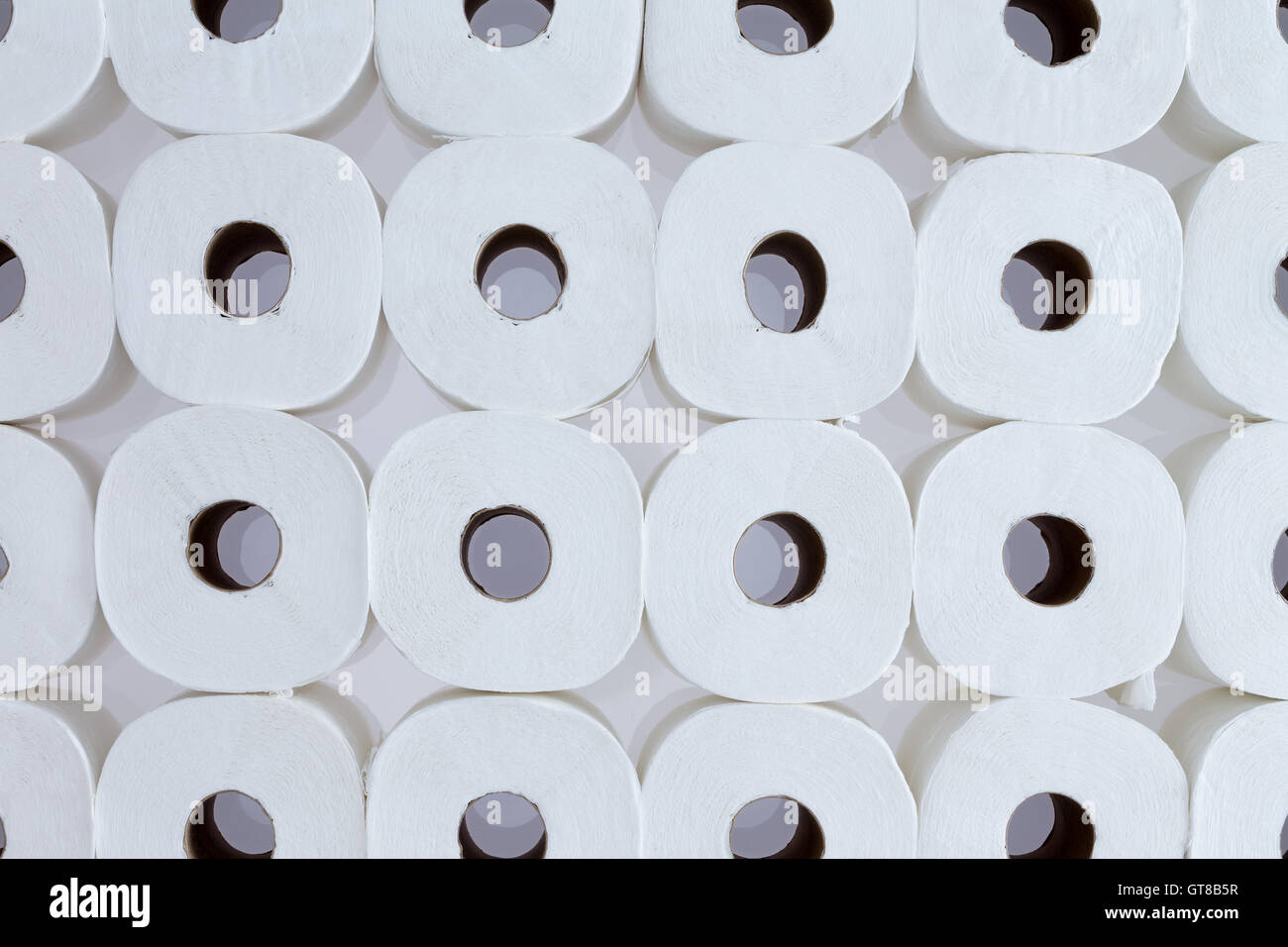 Full frame pattern di sfondo bianco di rotoli di carta igienica disposti in file ordinate visto dal di sopra - la carta igienica per tutti Foto Stock