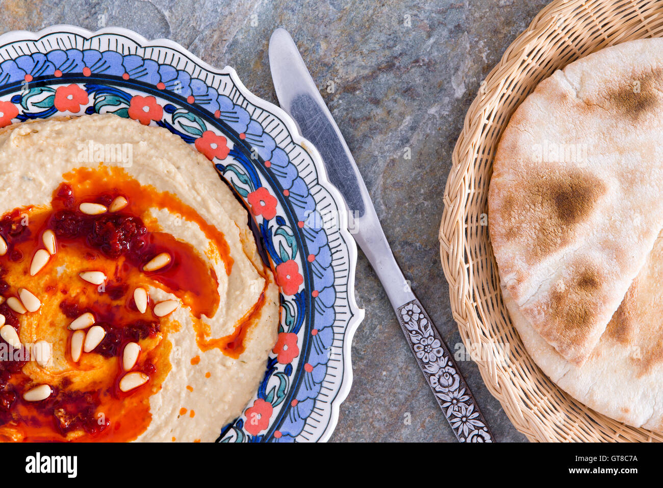 Hummus dip, una miscela nutriente di ceci, tahini, olio, il succo di limone e aglio, con pane appena sfornato pane pita in un cestello, vi Foto Stock