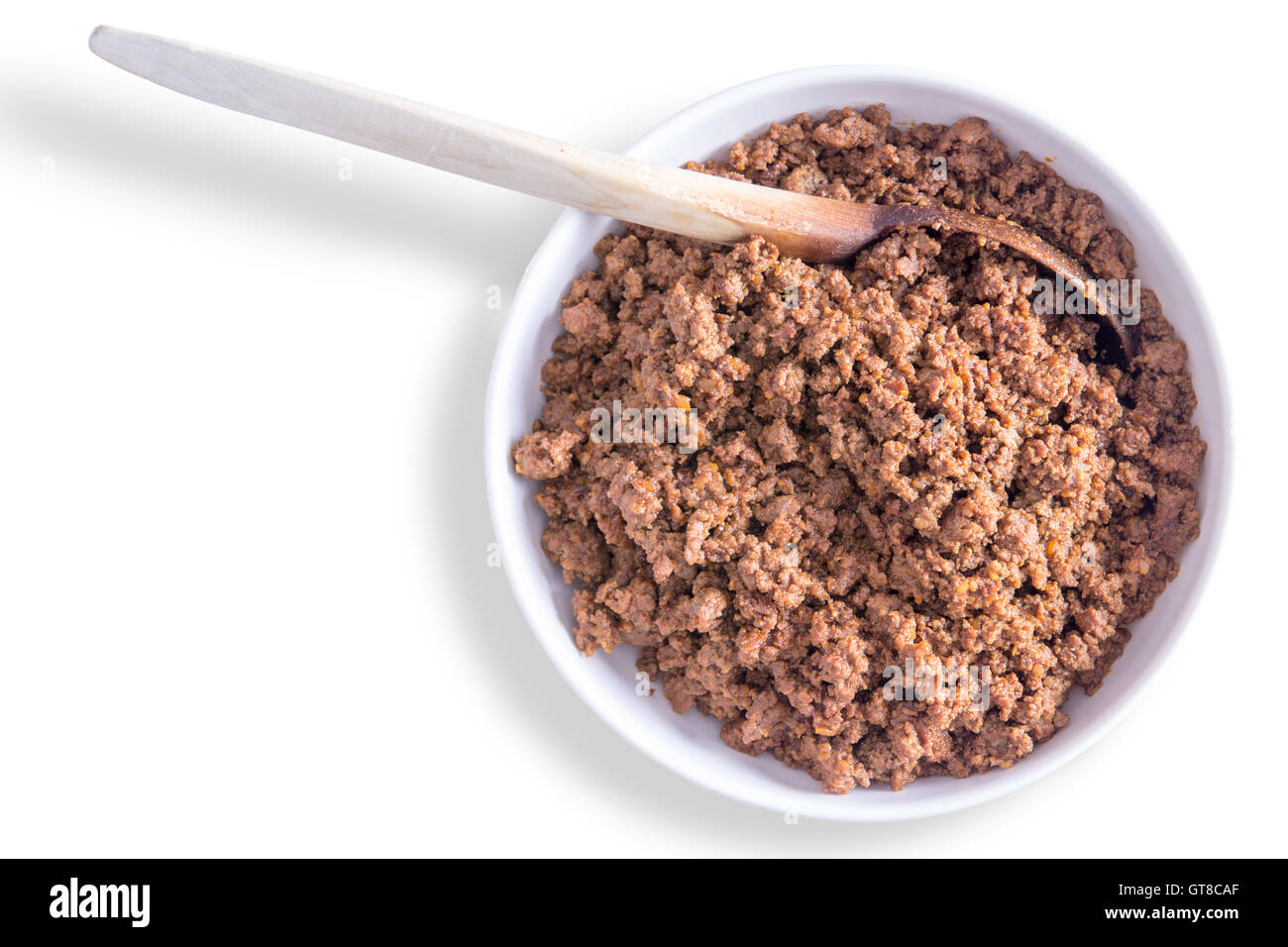 La vaschetta del preparato di fresco terreno salato o le carni bovine macinate miscela per riempimento o tortillas tacos con un cucchiaio di legno su un retro bianco Foto Stock