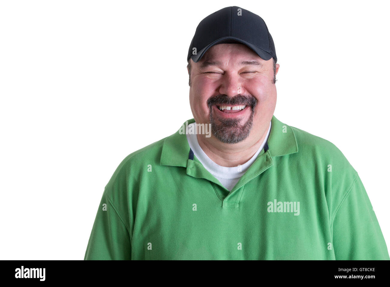 Ritratto di sovrappeso uomo che indossa camicia verde e nero Berretto da baseball di ridere davanti a uno sfondo bianco, testa e spalle Foto Stock