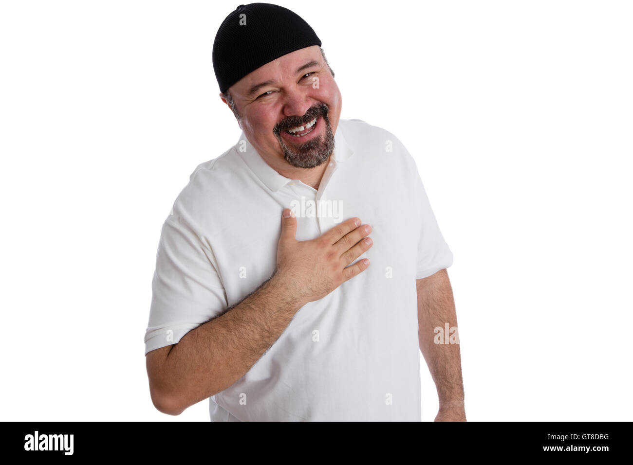 Felice l'uomo soddisfatto che mostra la sua gratitudine nella preghiera tenendo la mano al suo cuore come egli sorride gioiosamente fino alla telecamera per visualizzare Foto Stock