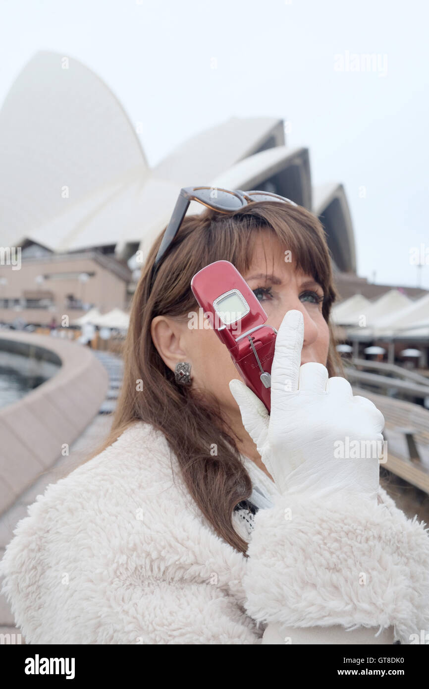 Una donna usa Samsung T500 telefono cellulare alla Opera House di Sydney Australia Foto Stock