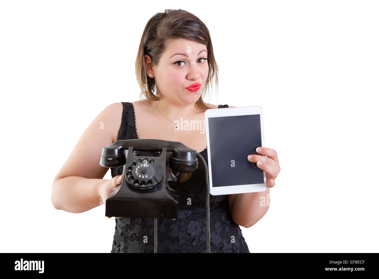 Donna carismatica confrontando il vecchio e moderna tecnologia tenendo in mano una vecchia terra rotante linea strumento telefonico e un ta Foto Stock