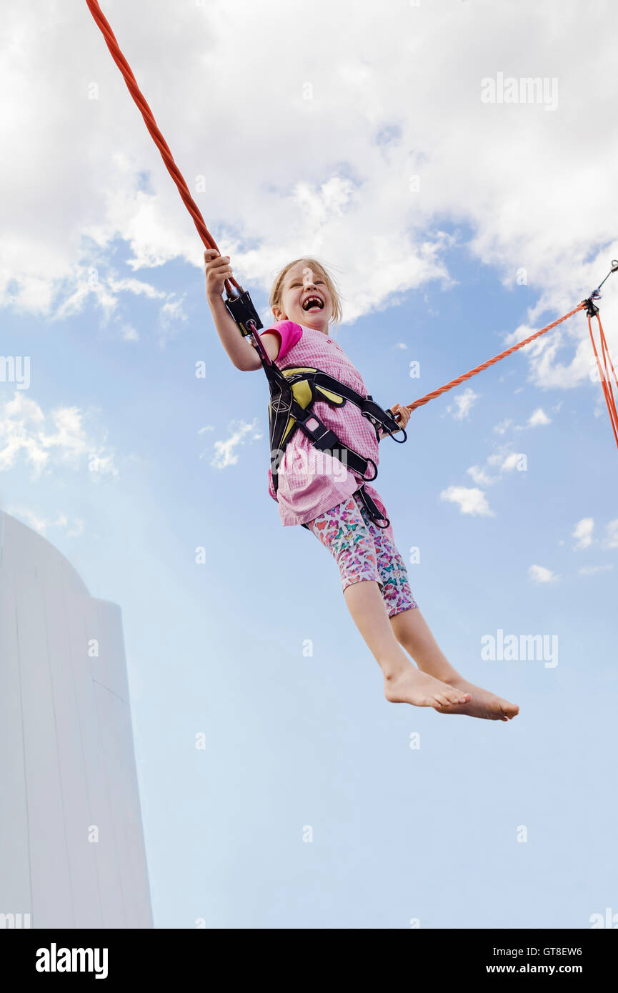 6 anno vecchia ragazza jumping con un trampolino elastico in una giornata di sole, Germania Foto Stock
