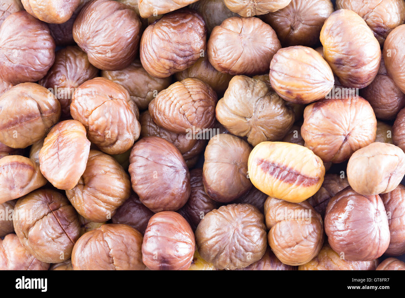 Full frame texture di sfondo di fresco intero di castagne arrostite per un sano autunno stagionale snack o per uso in cucina Foto Stock