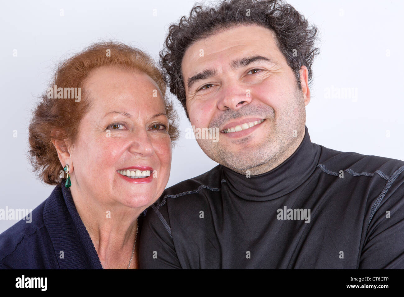 Felice senior madre con i capelli rossi in piedi vicino alla sua confidente figlio adulto in black turtleneck shirt Foto Stock