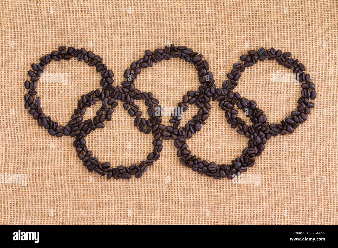 RIO DE JANEIRO - 10 maggio 2016:Giochi Olimpici concetto formata di Roasted Brown i chicchi di caffè su un tessuto naturale o di tela hessian te Foto Stock