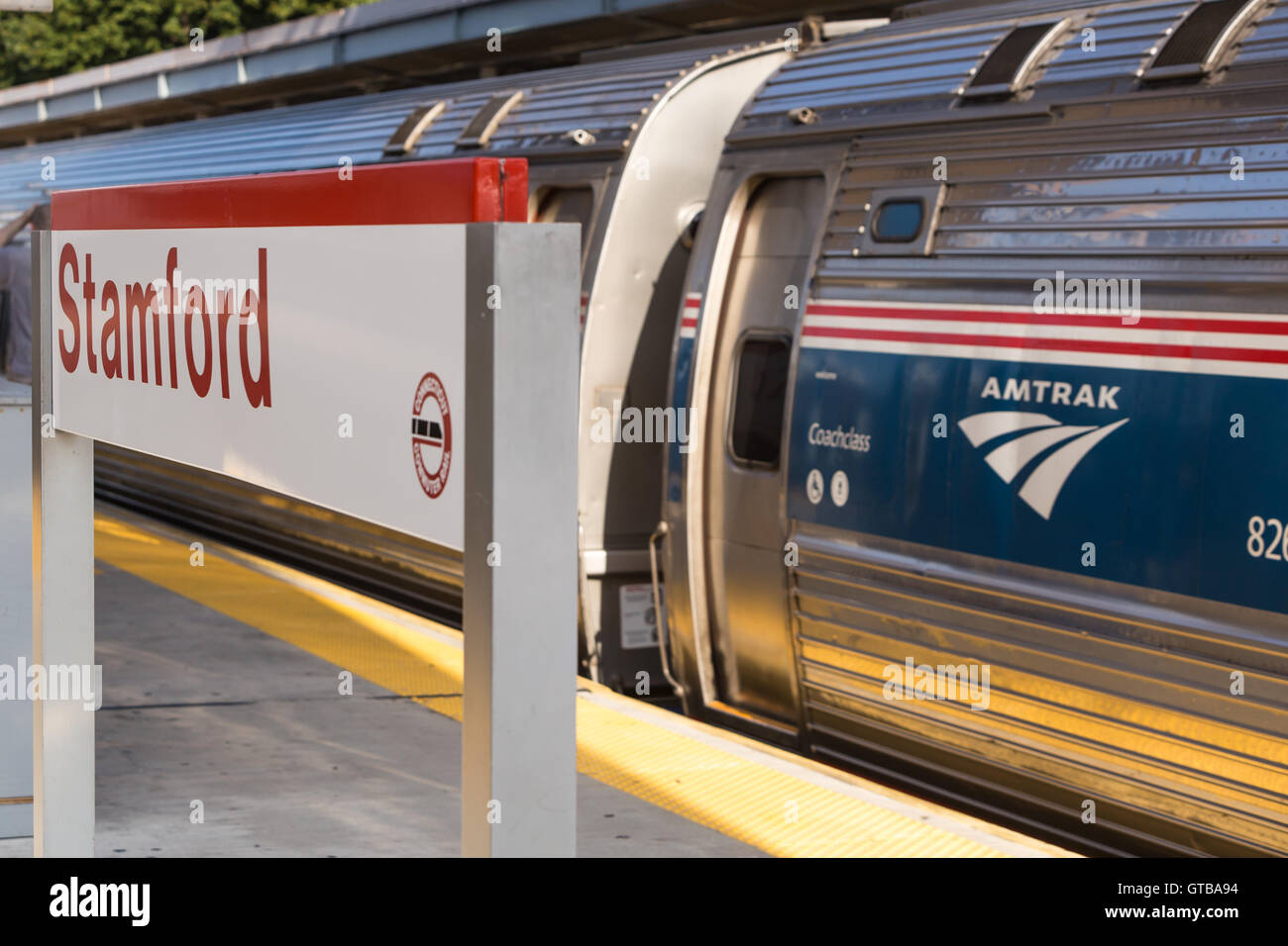 Un northbound Amtrak Northeast treno regionale riprende velocità che si diparte dalla stazione di Stamford a Stamford, Connecticut. Foto Stock