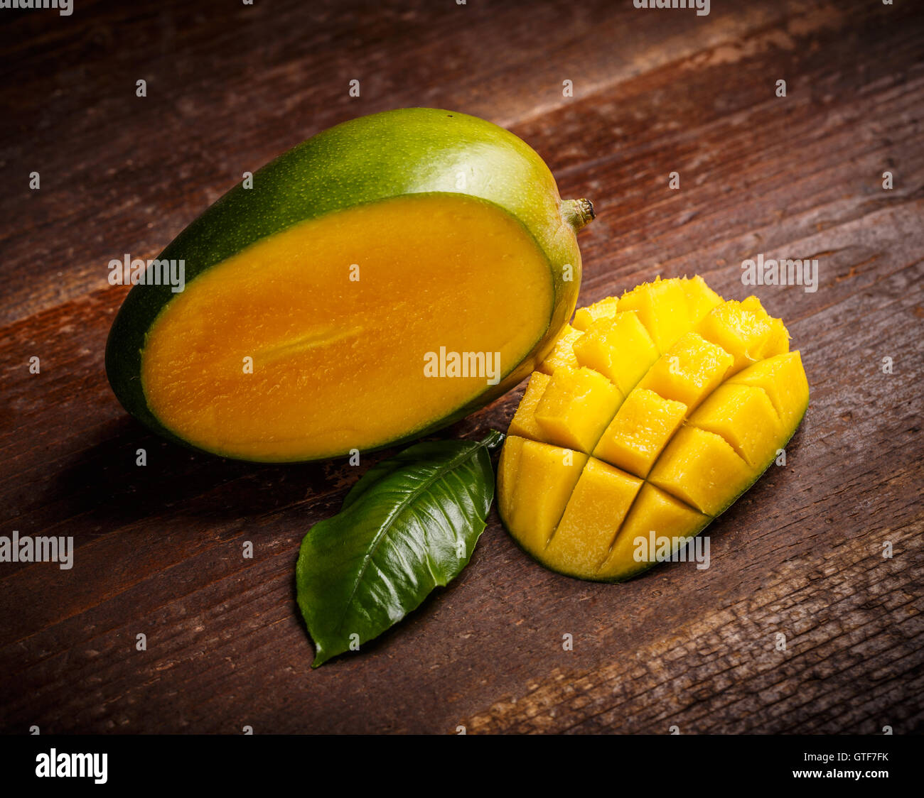 Mango frutta e cubetti di mango su sfondo di legno Foto Stock