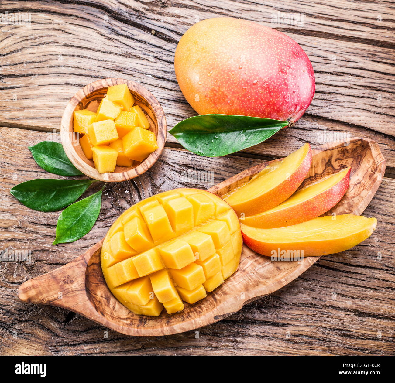 Mango frutta e cubetti di mango sul tavolo di legno. Foto Stock
