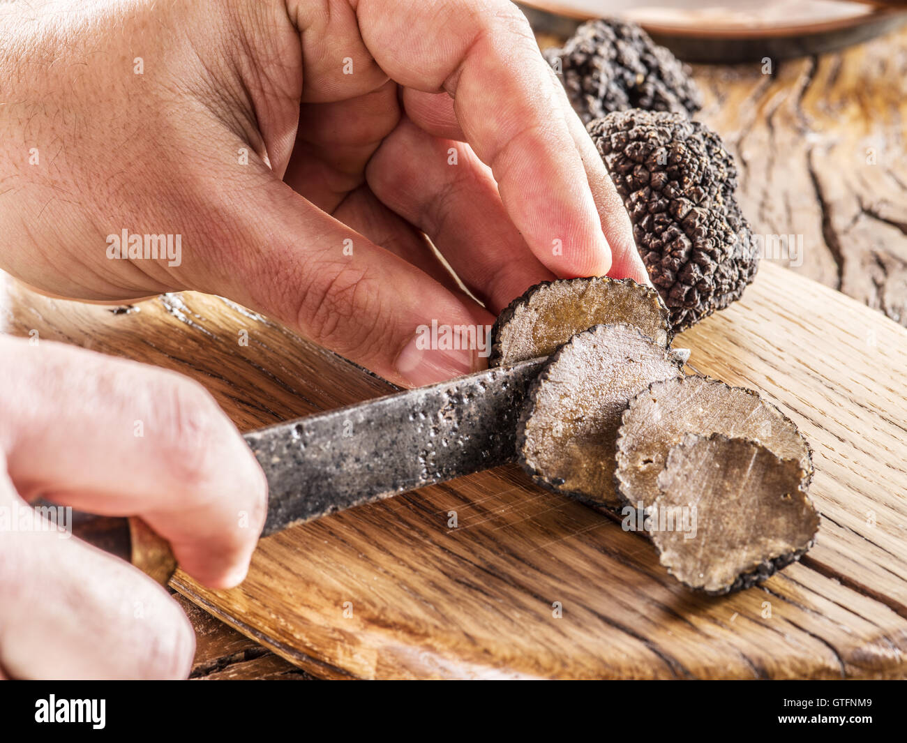 Il taglio del tartufo nero sulla tavola di legno. Foto Stock