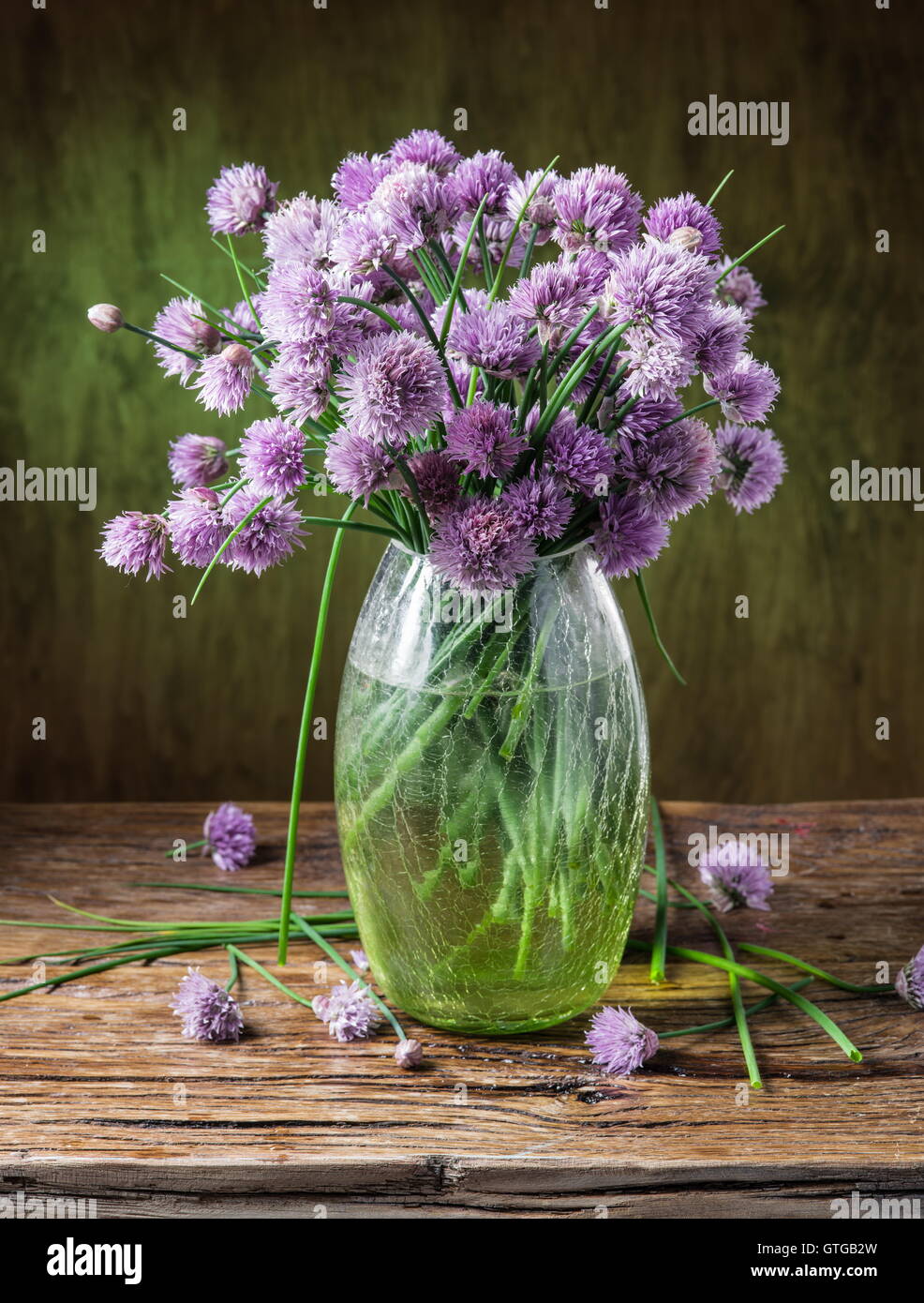 Bouquet di cipolla (erba cipollina) fiori in vaso sul tavolo di legno. Foto Stock