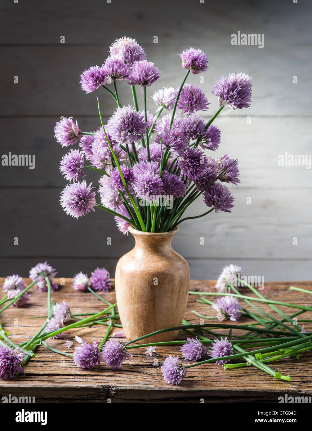 Bouquet di cipolla (erba cipollina) fiori in vaso sul tavolo di legno. Foto Stock