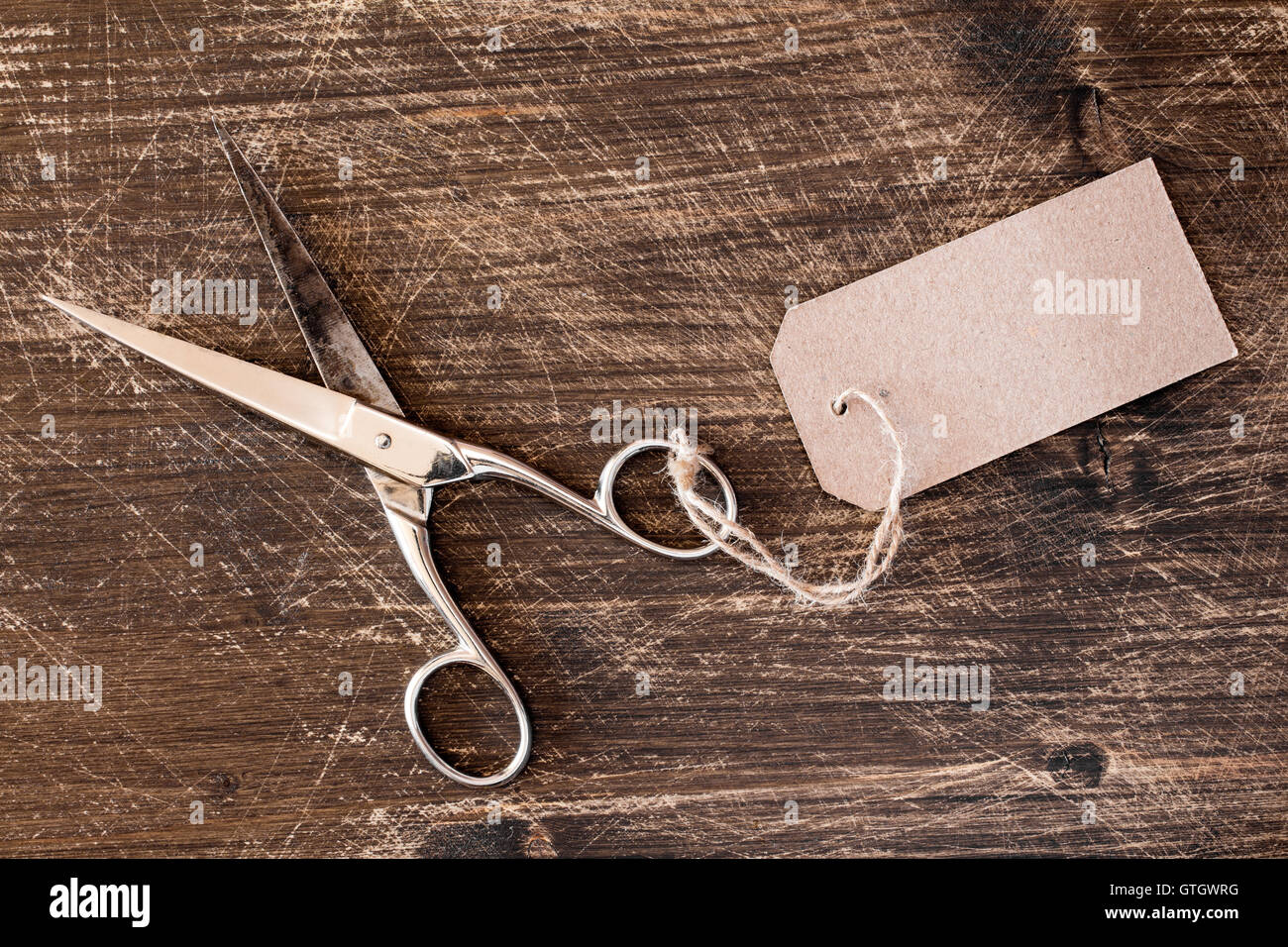 Forbici di metallo con tag vuoto sulla scrivania in legno Foto Stock