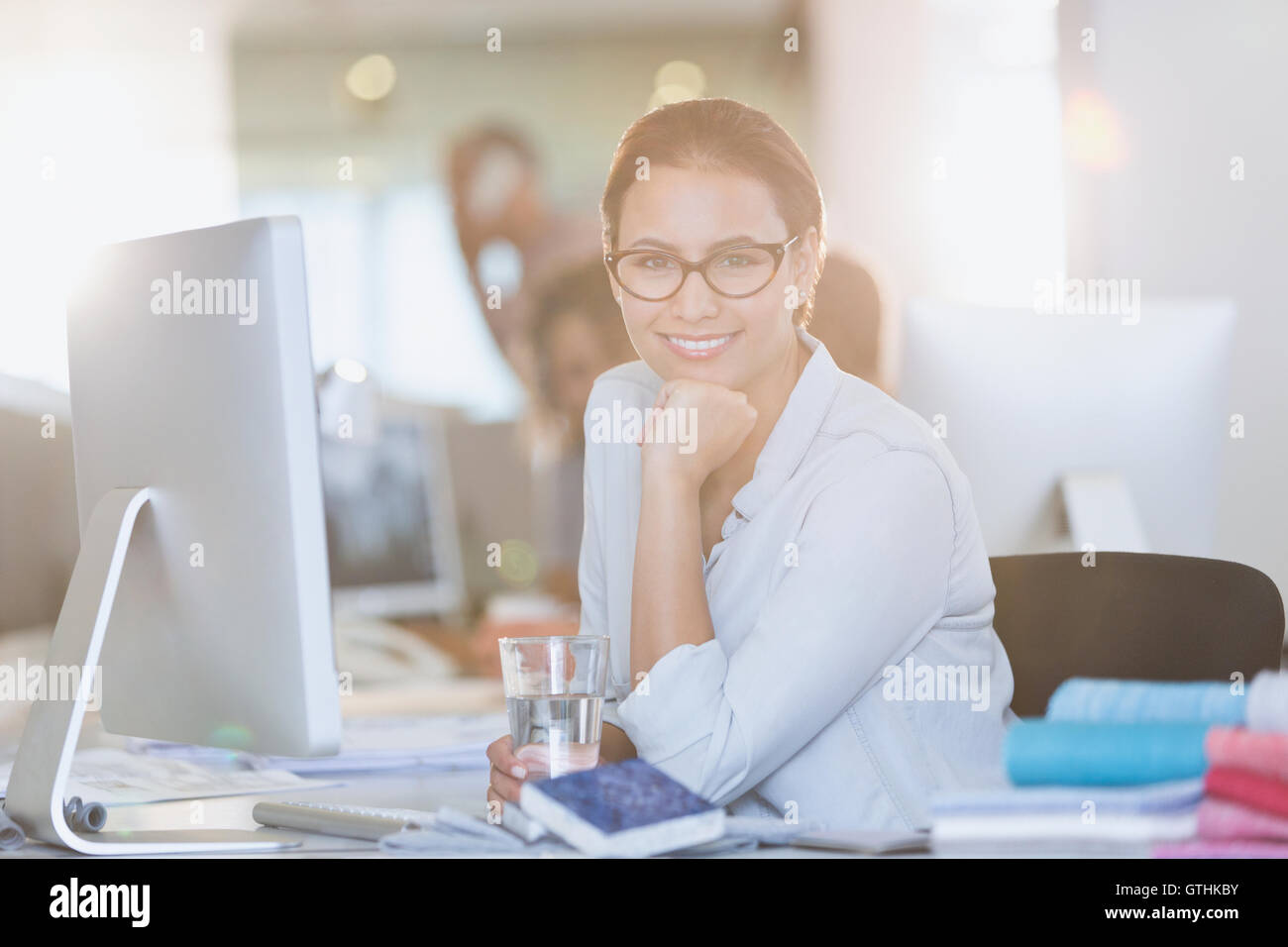 Ritratto sorridente imprenditrice a computer in ufficio Foto Stock
