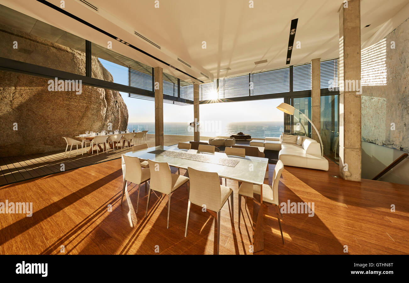 Sole che splende nel lusso moderno home vetrina sala da pranzo con vista oceano Foto Stock