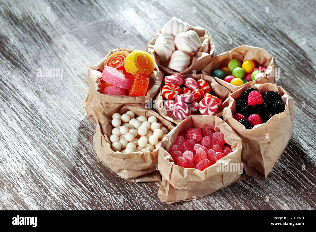 Sacchetti di caramelle colorate sul tavolo di legno Foto Stock