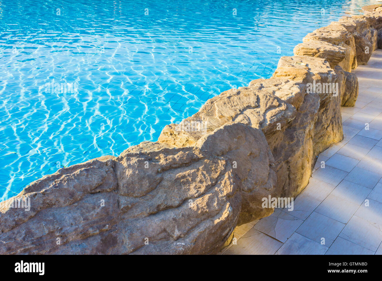 Lato della Piscina è bordato con pietra Foto Stock