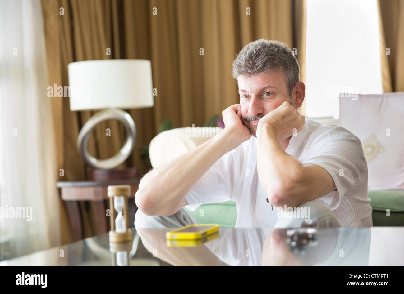 Uomo di mezza età guardando ora orologio e in attesa di una chiamata Foto Stock