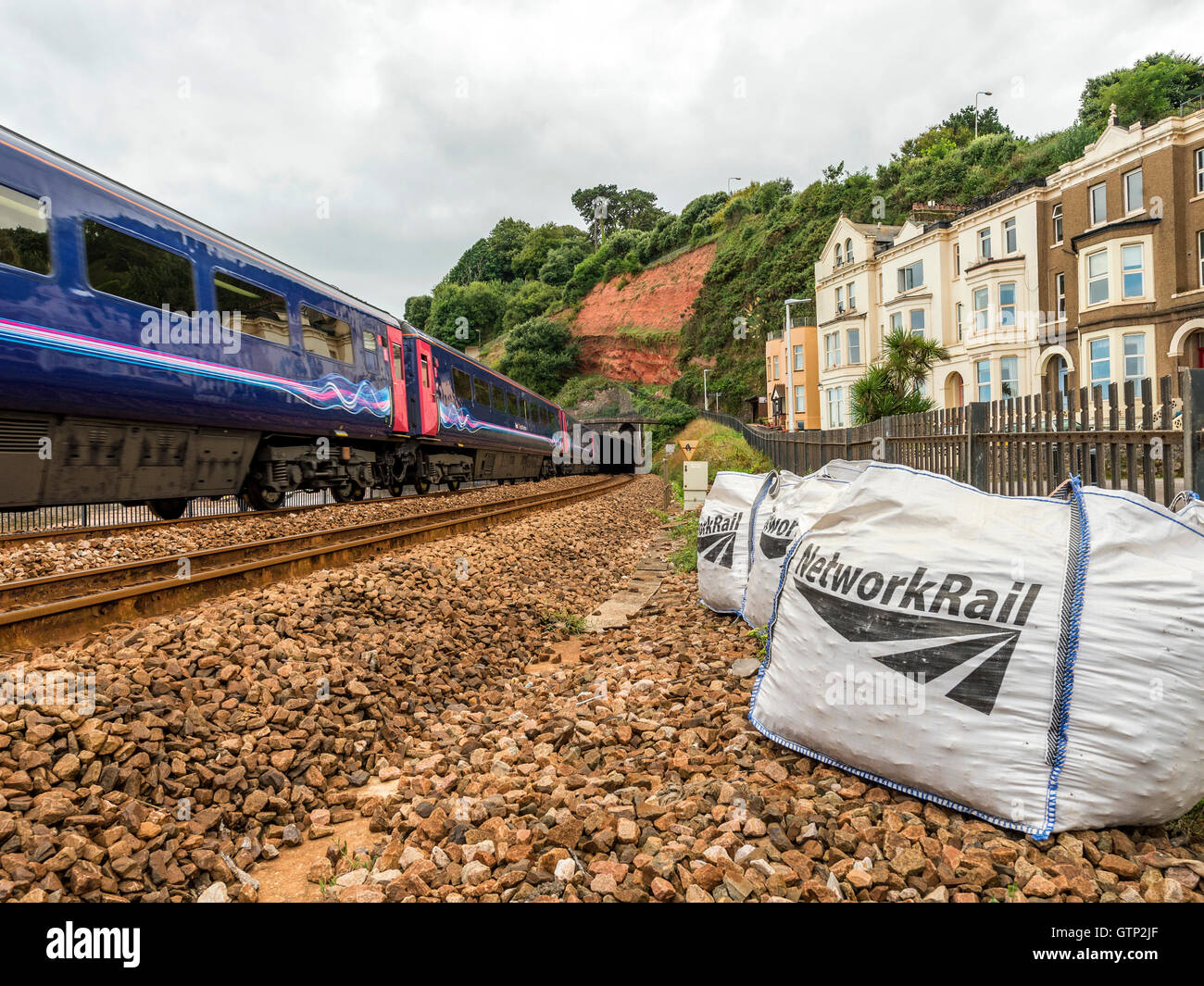 Paesaggio raffigurante la pittoresca prima di Great Western Riviera linea ferroviaria a Dawlish, con passaggio di treno. Foto Stock