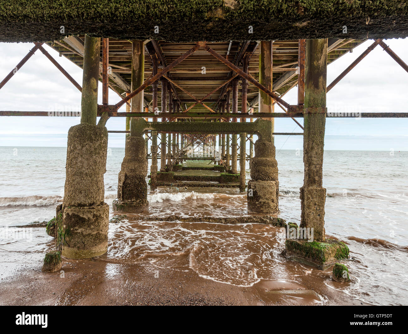 Paesaggio raffigurante la riva del mare lungo la spiaggia di Teignmouth a Teignmouth, con vedute del Grand Pier struttura. Foto Stock