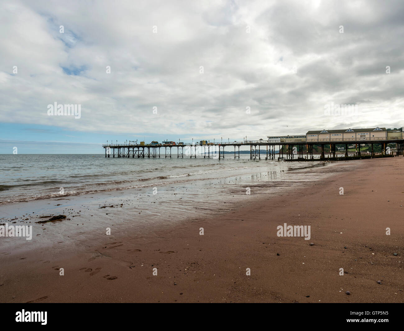 Paesaggio raffigurante la riva del mare lungo la spiaggia di Teignmouth a Teignmouth, con vedute del Grand Pier. Foto Stock