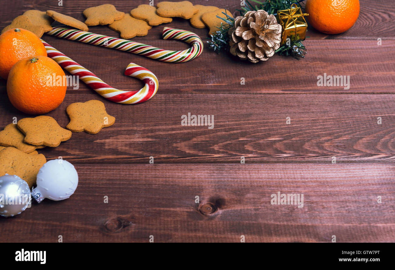 Su una scrivania in legno sfondo composizione di Natale - candy cane, pasta di figurine, Natale-ramo di albero palle di Natale, uvetta, Foto Stock