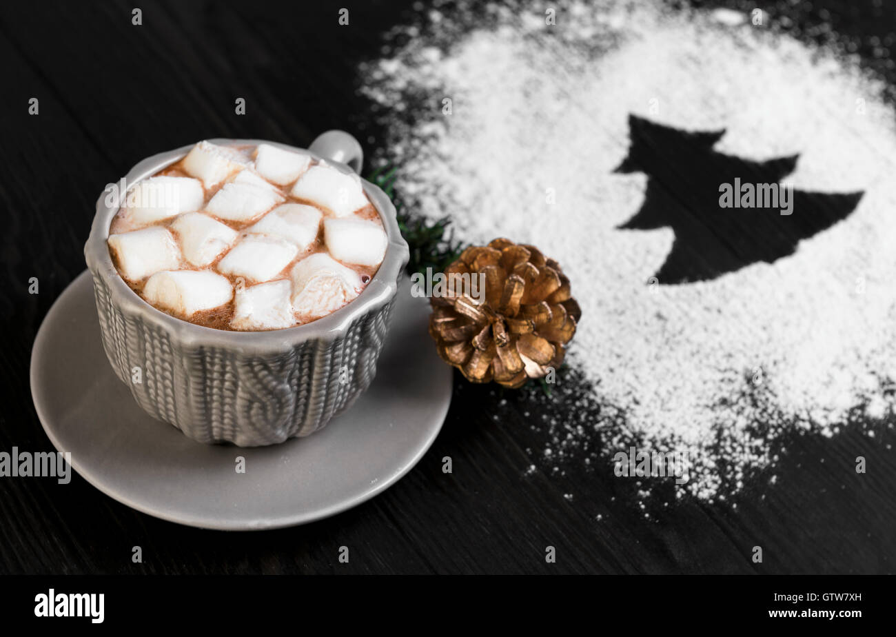 Su un tavolo di legno coppa di sfondo e piattino grigio disegno di lavorazione a maglia con del cioccolato amaro e marshmallow, Natale-ramo di albero w Foto Stock