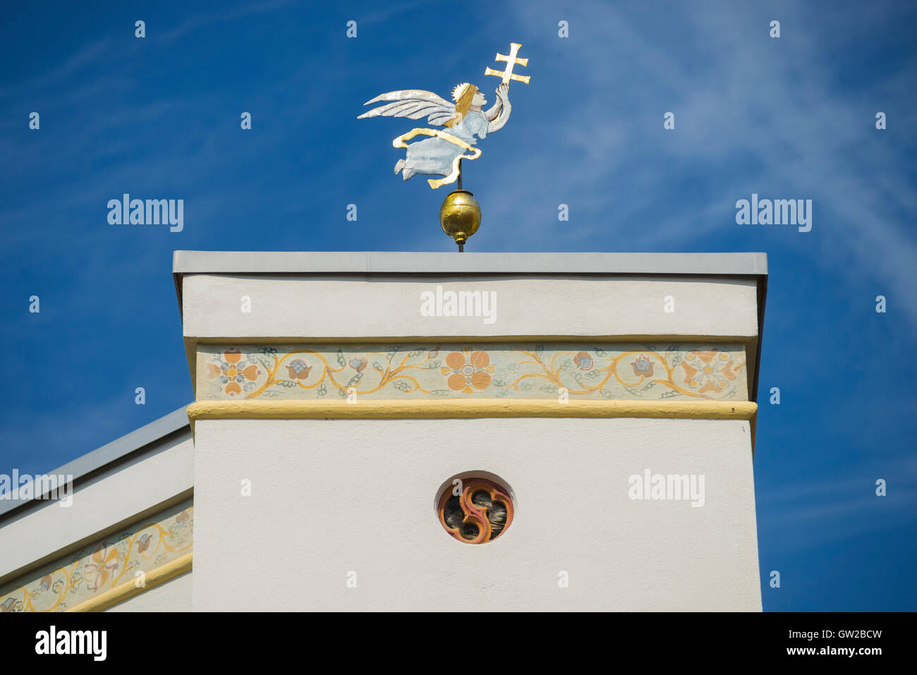 Metallo dorato la figura di un angelo con la croce contro il cielo blu su edificio medievale nel centro storico della città di Wasserburg, Baviera, Germania Foto Stock