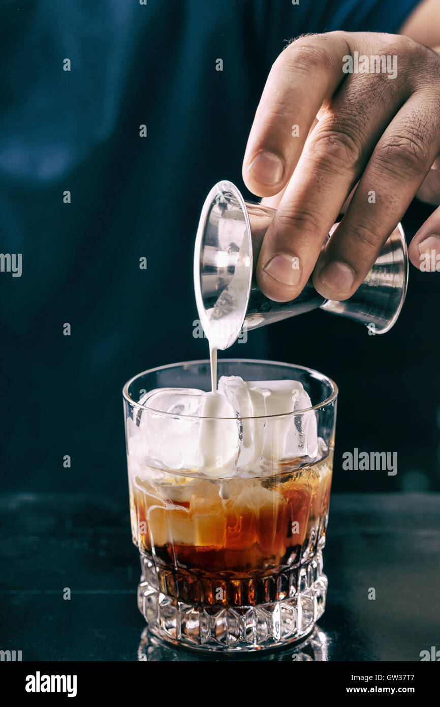 Barman rendendo white russian cocktail al night club Foto Stock