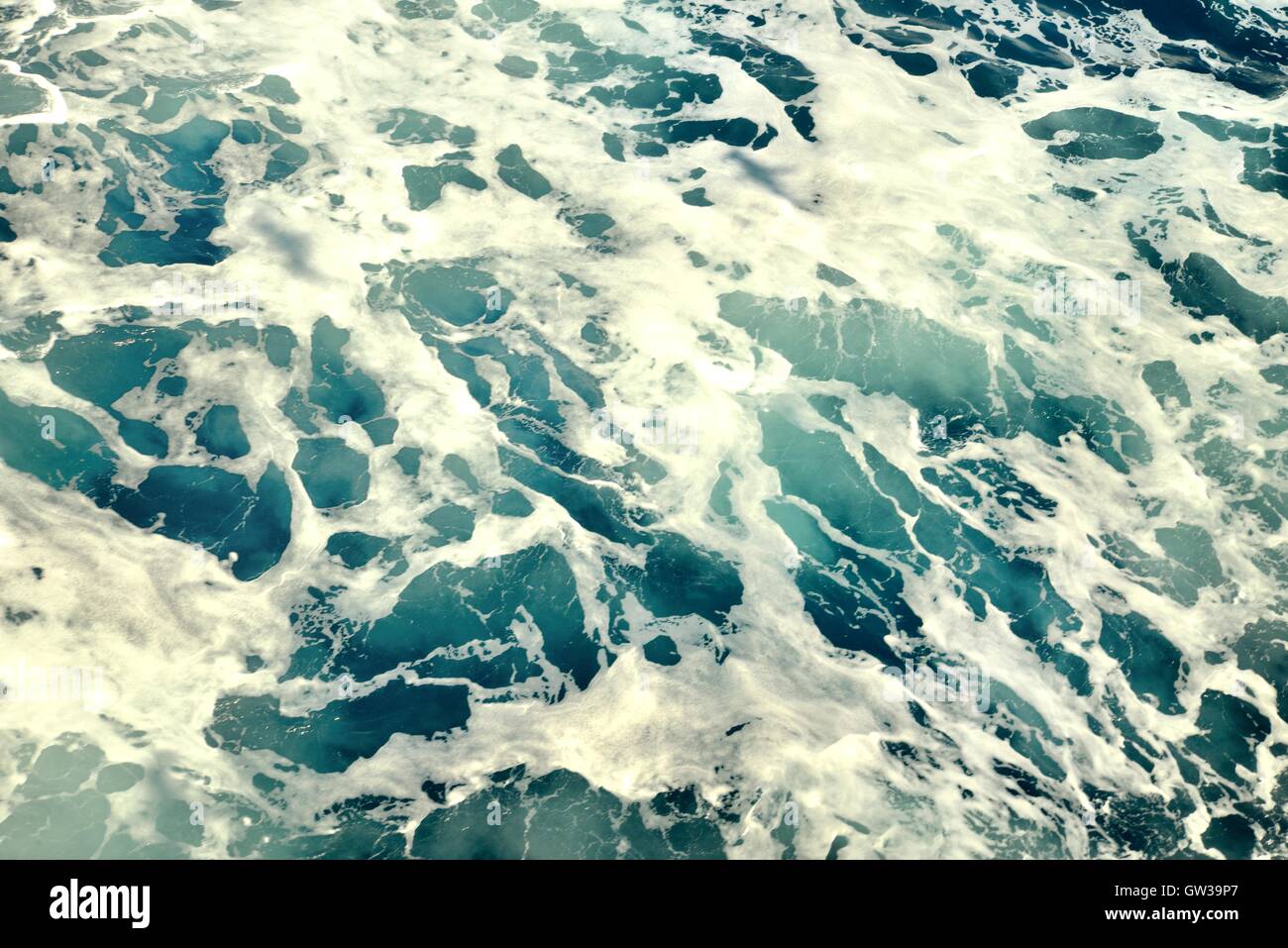 Mare mosso con schiuma bianca e blu verde acqua. Foto Stock