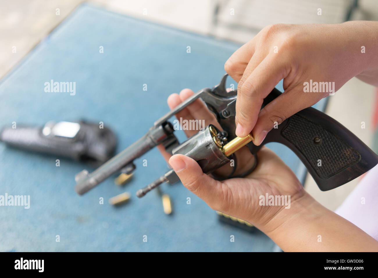 Persone caricare i proiettili nella pistola revolver prima delle riprese Foto Stock