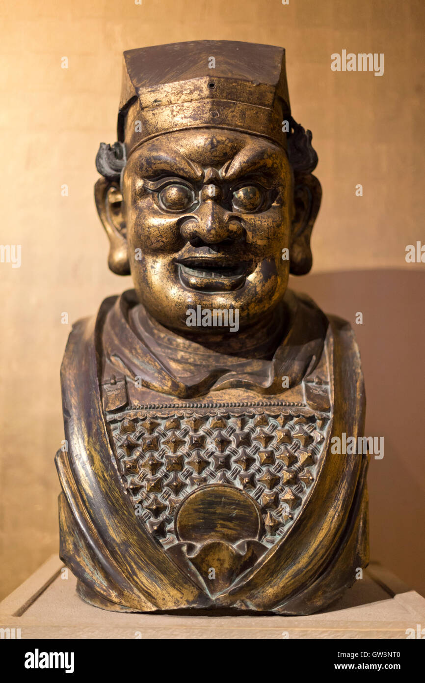 Il XIV secolo cinese della dinastia Yuan in bronzo dorato della testa di un buddista custode figura, camera 33 British Museum di Londra, Regno Unito. Foto Stock