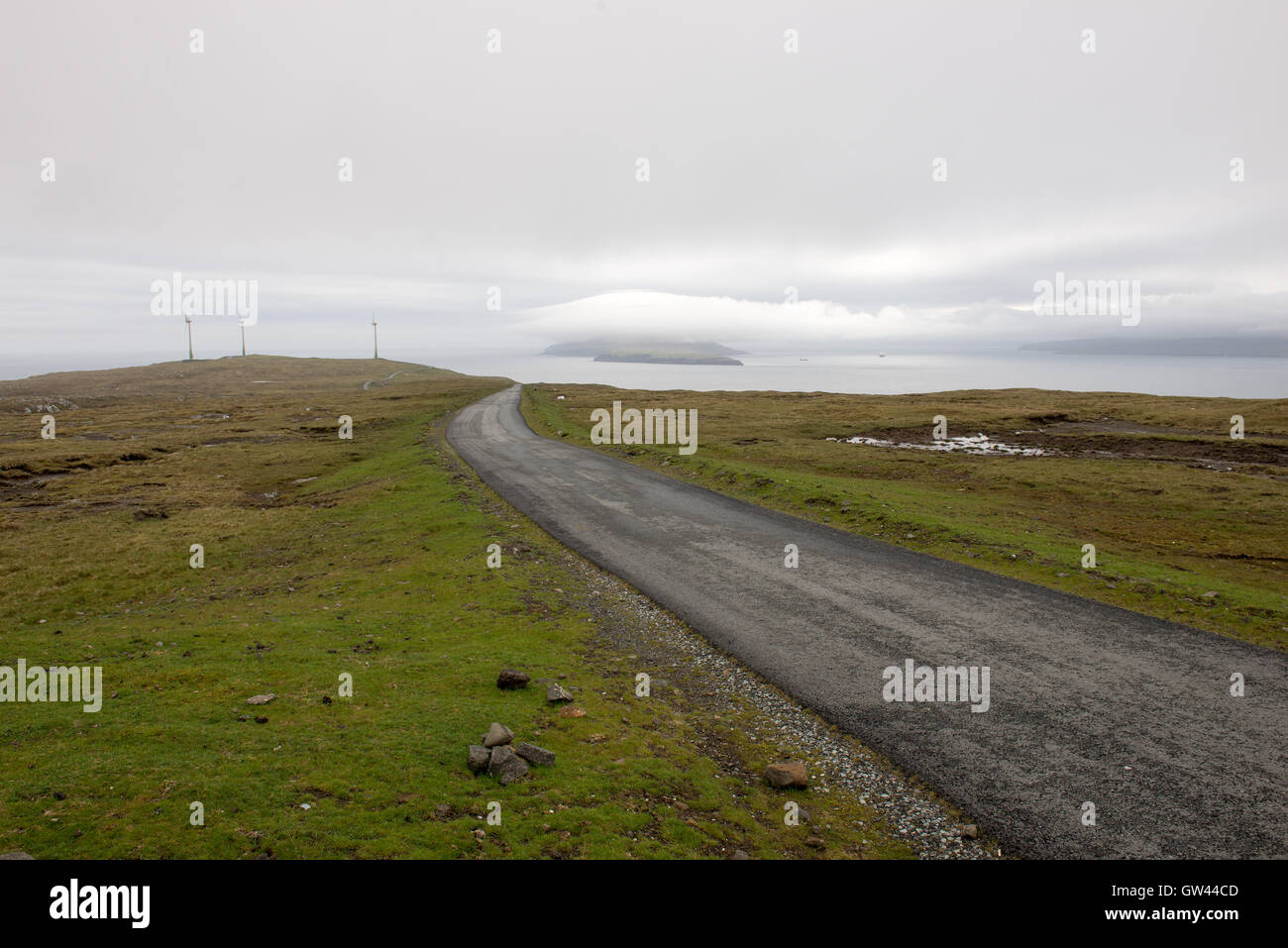 Sulla Strada delle Isole Faerøer nel sud di Eysturoy con mulini a vento e nolsoy Foto Stock