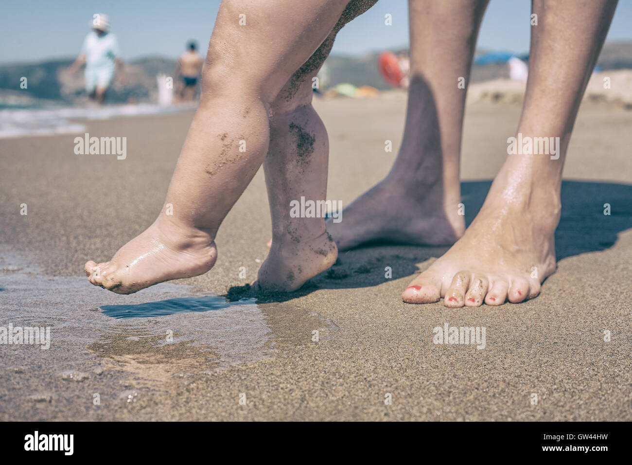 La madre e il bambino piedi camminando sulla spiaggia di sabbia per la prima volta Foto Stock