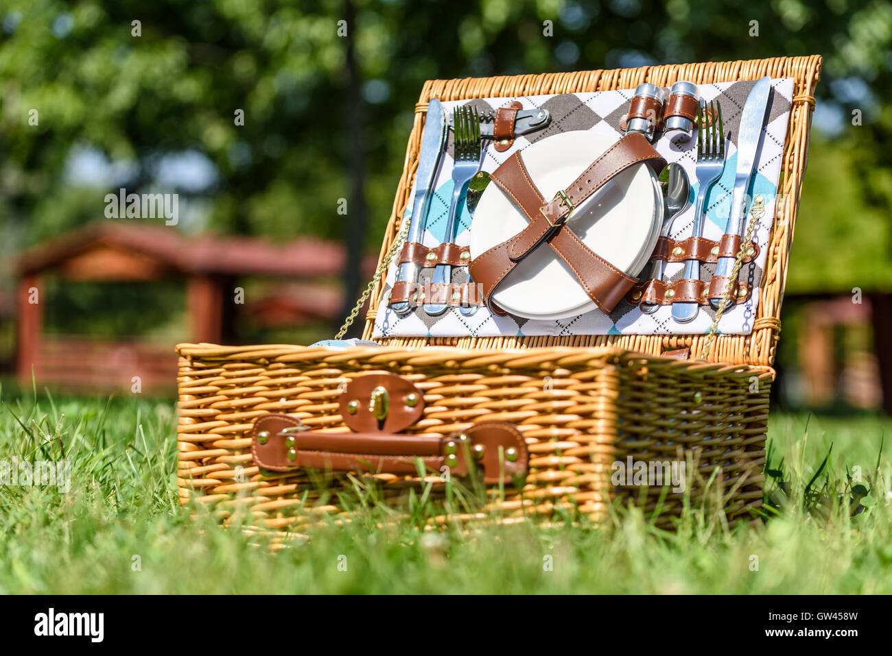 Aperto Cesto picnic con posate in primavera erba verde Foto Stock