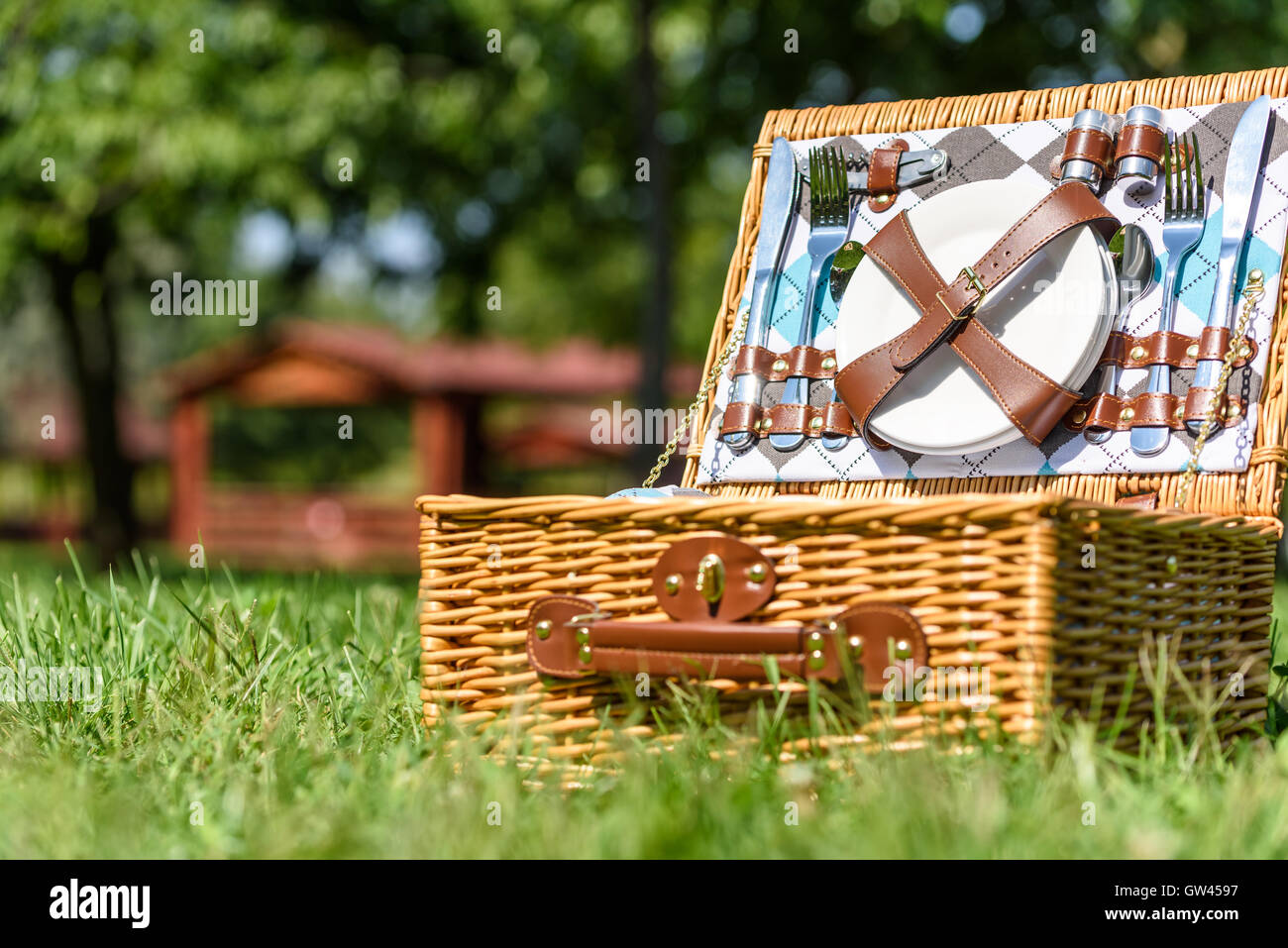 Aperto Cesto picnic con posate in primavera erba verde Foto Stock