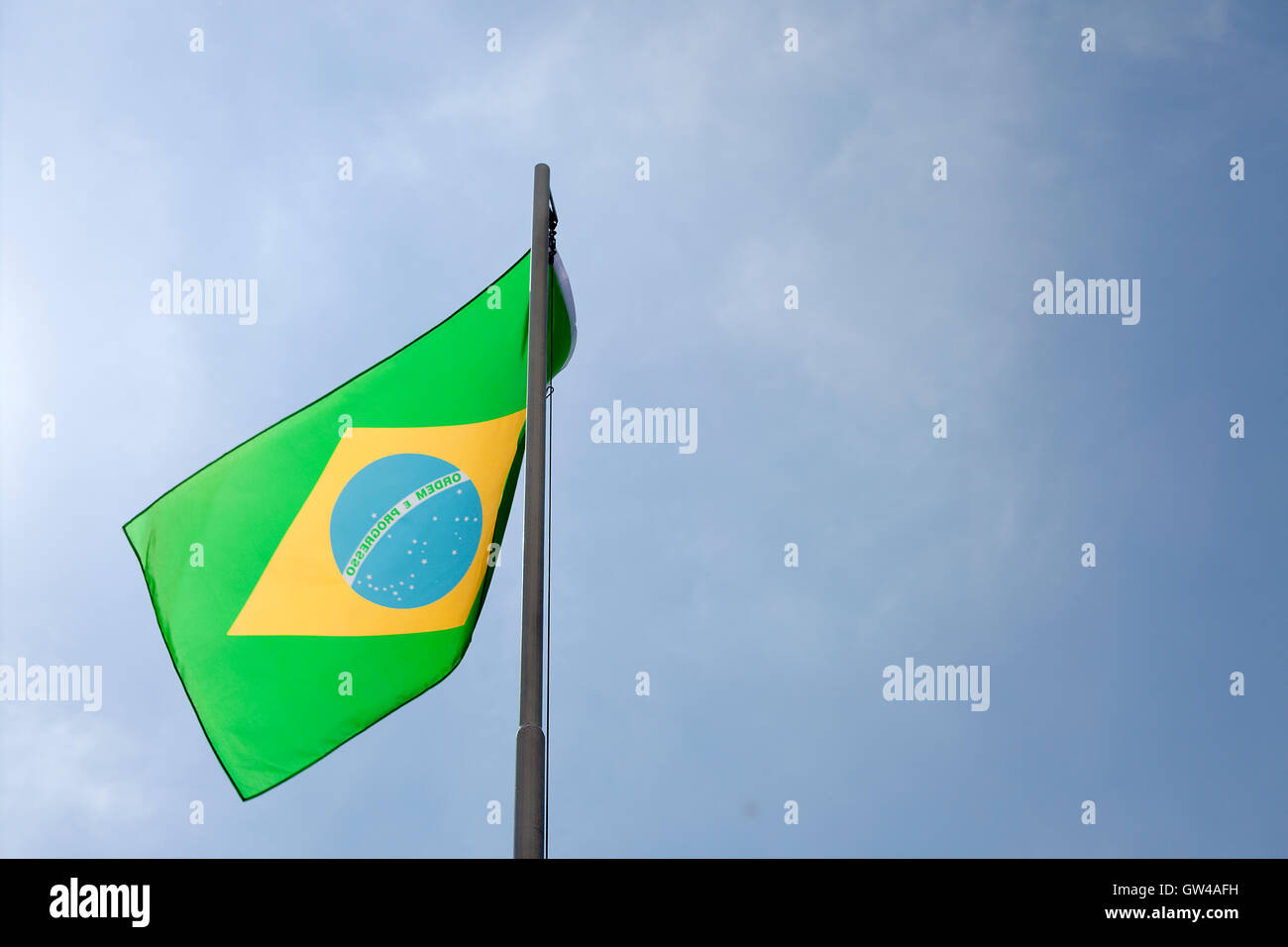 Bandiera Nazionale del Brasile su un pennone di fronte blu cielo Foto Stock