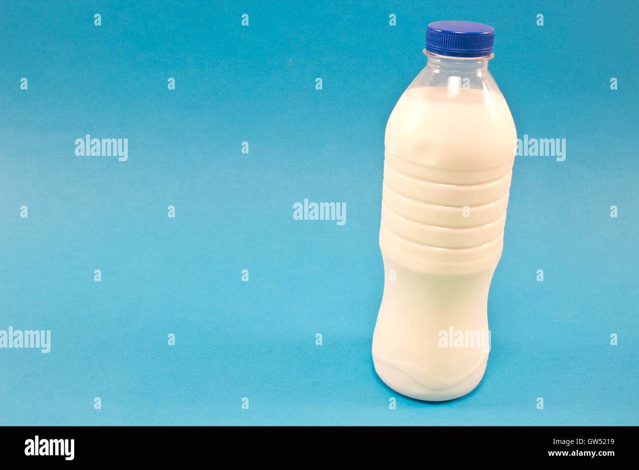 Bottiglia di latte isolate su sfondo blu Foto Stock