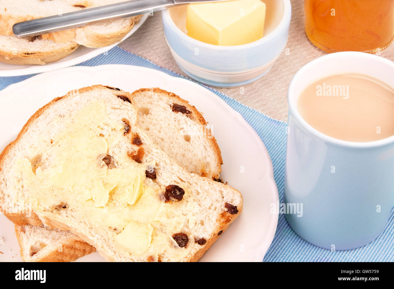 Frutta tagliata focaccia con uva sultanina e una tazza di tè con latte. Messa a fuoco selettiva Foto Stock