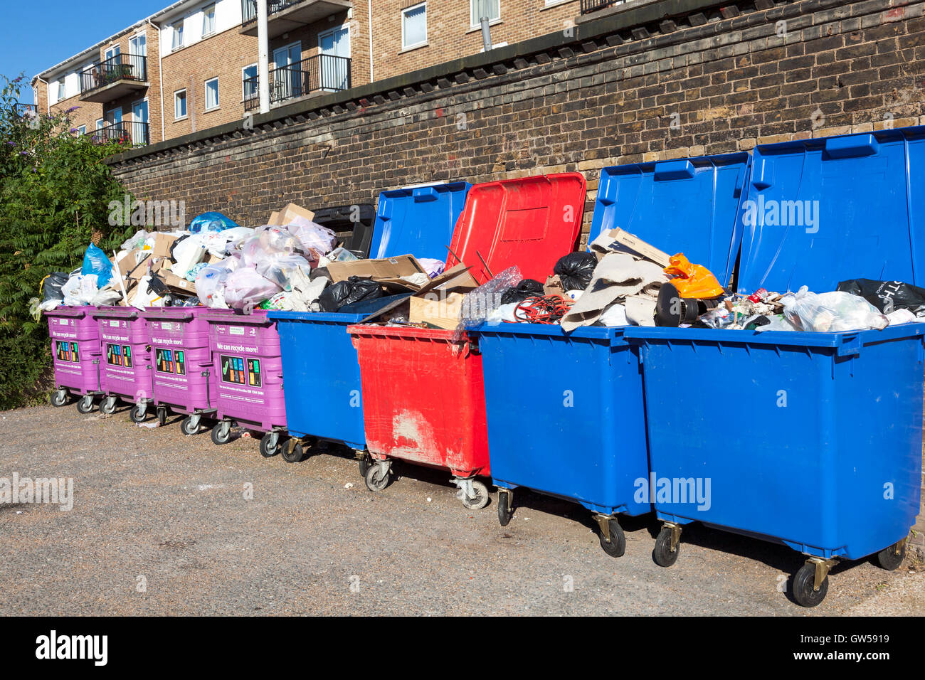 Traboccante miscelati cassonetti per il riciclaggio in Limehouse, Tower Hamlets, Londra Foto Stock