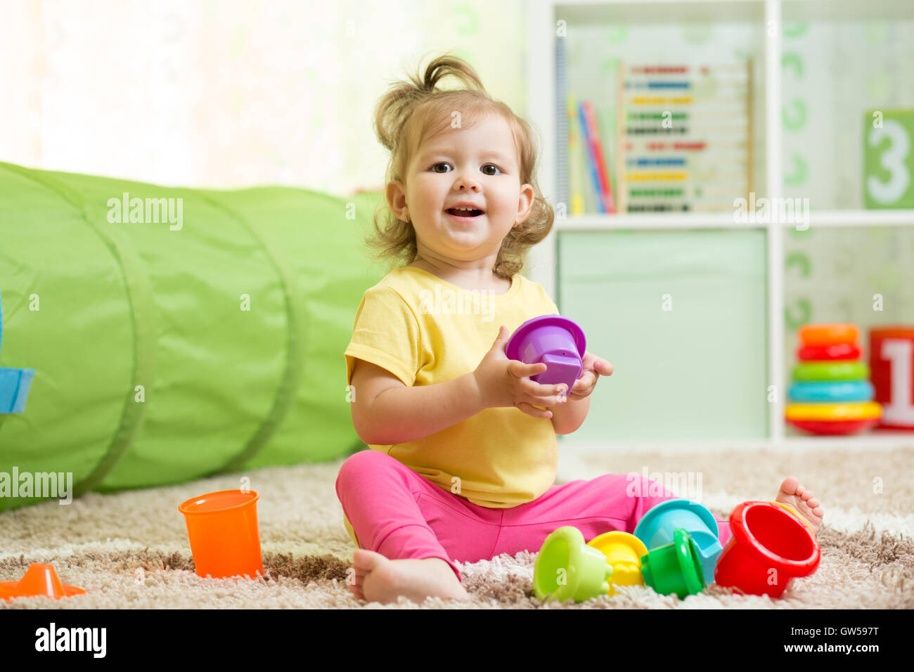 Bambino felice bambina gioca con giocattoli per interni Foto Stock