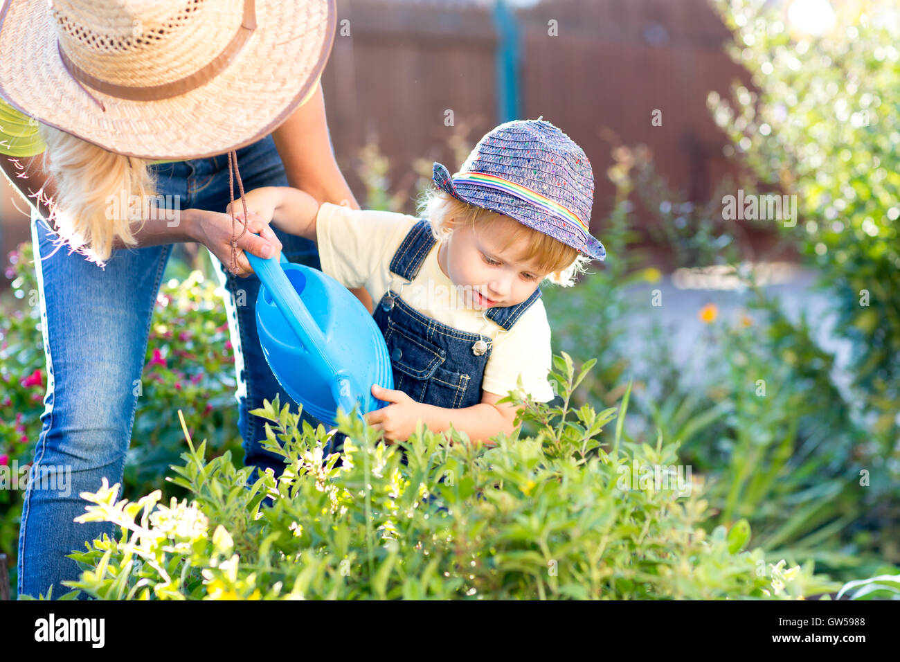 Bambino ragazzo aiuta a madre lavora in giardino Foto Stock