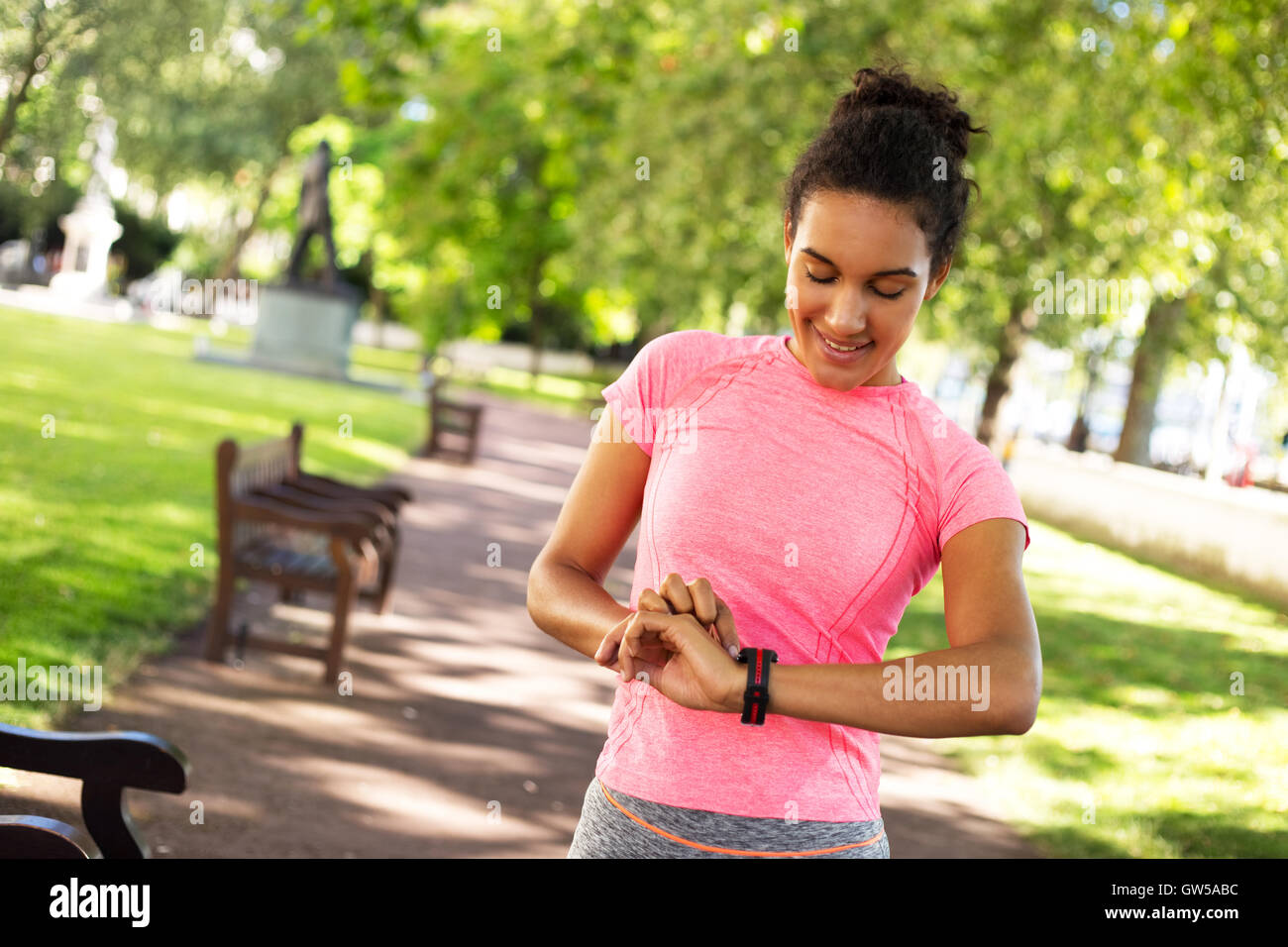 Giovane donna controllando la sua frequenza cardiaca sul suo orologio fitness Foto Stock