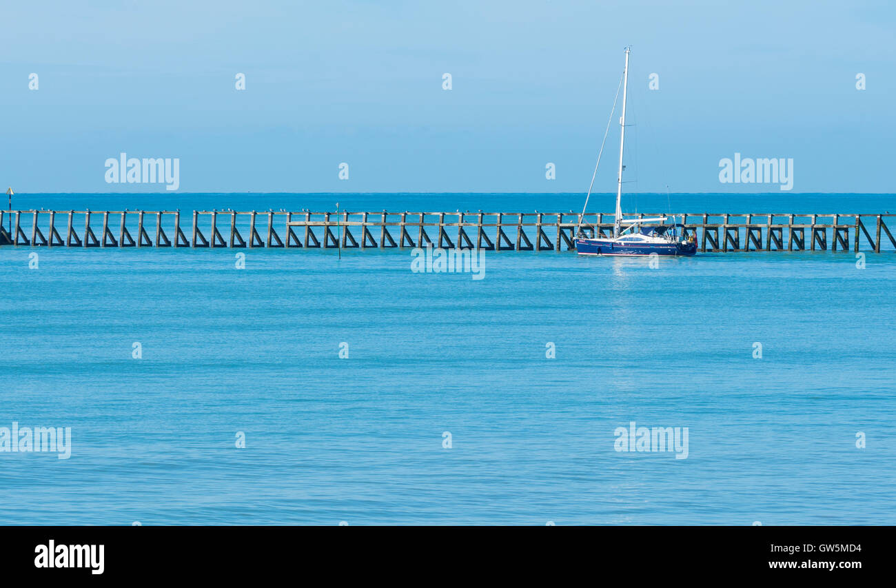Mare calmo. Yacht di uscire da un estuario del fiume su una calma piatta sul mare blu. Foto Stock