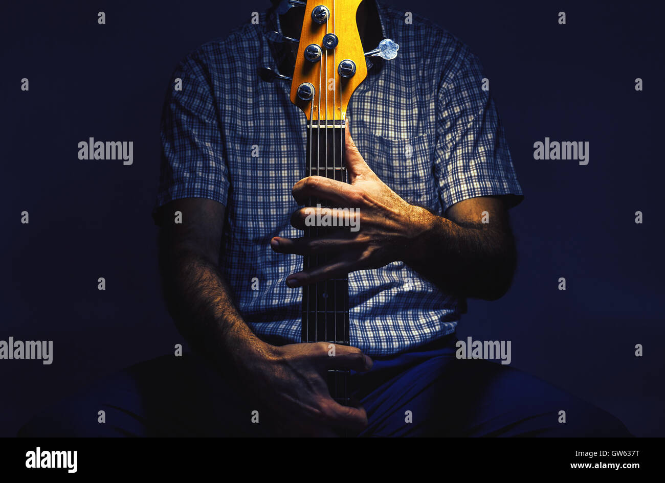 Le mani di un bassista, closeup vista su uno strumento e il corpo. Foto Stock