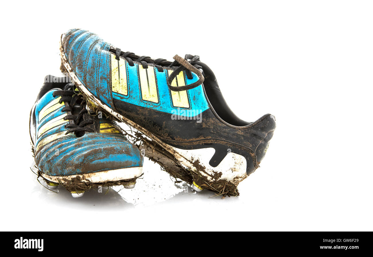 Terreni fangosi, scarpe da calcio su sfondo bianco Foto Stock