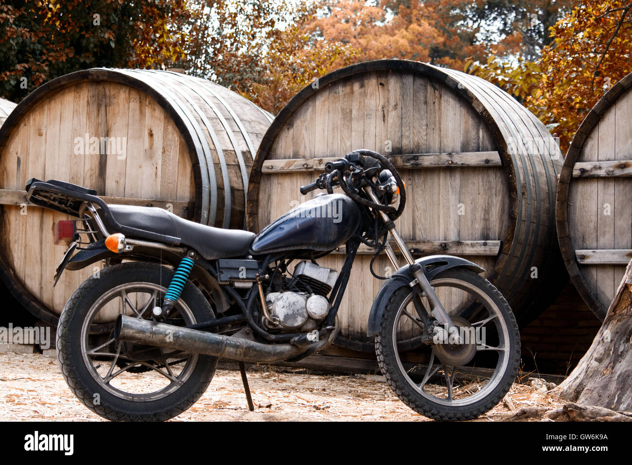 Motociclo nero su uno sfondo con un cilindro di grandi dimensioni per il vino Foto Stock