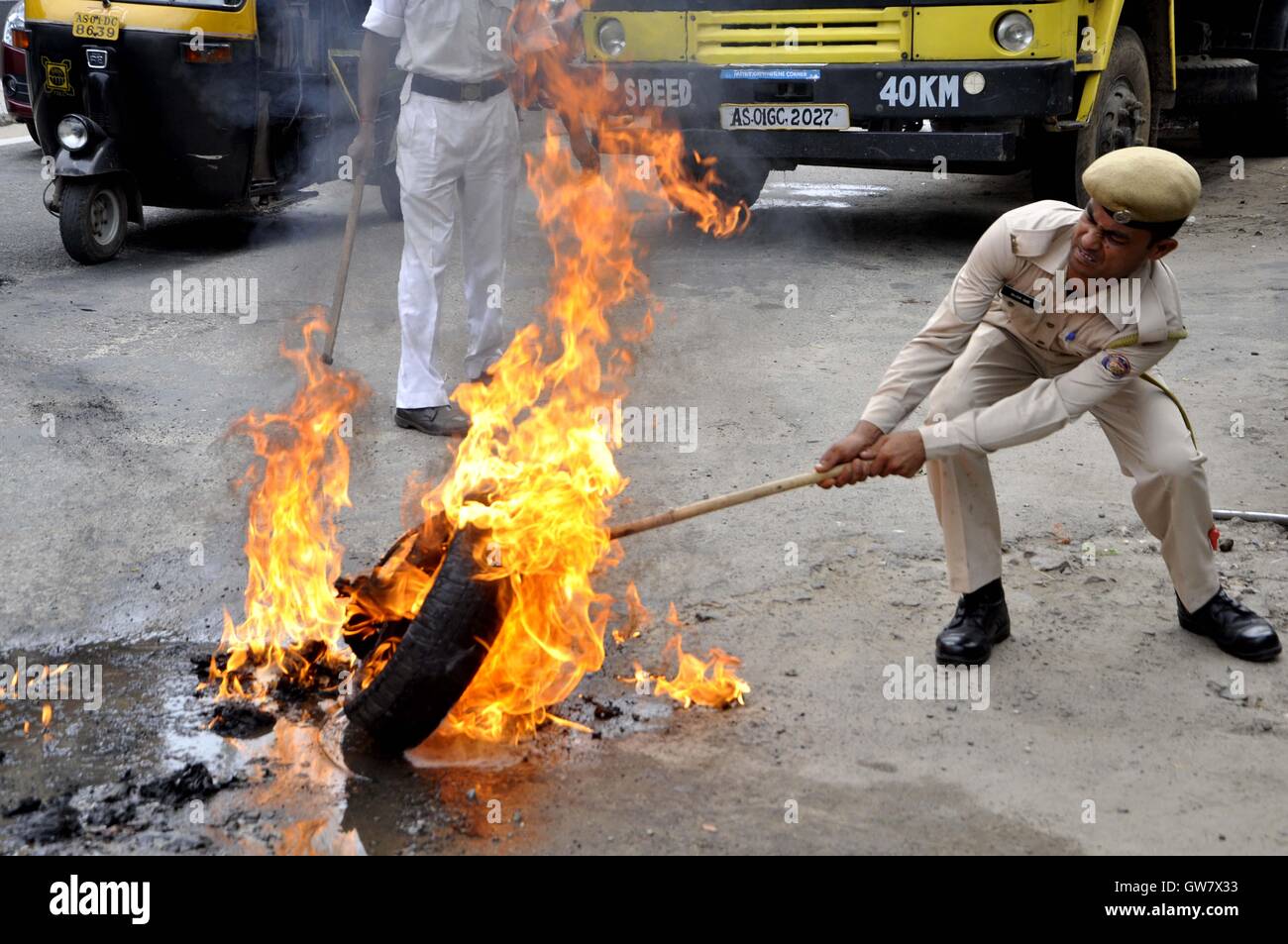 Manifestanti masterizzare pneumatico durante il Nationwide strike chiamato dai sindacati di Guwahati, India il 2 settembre 2016 Foto Stock