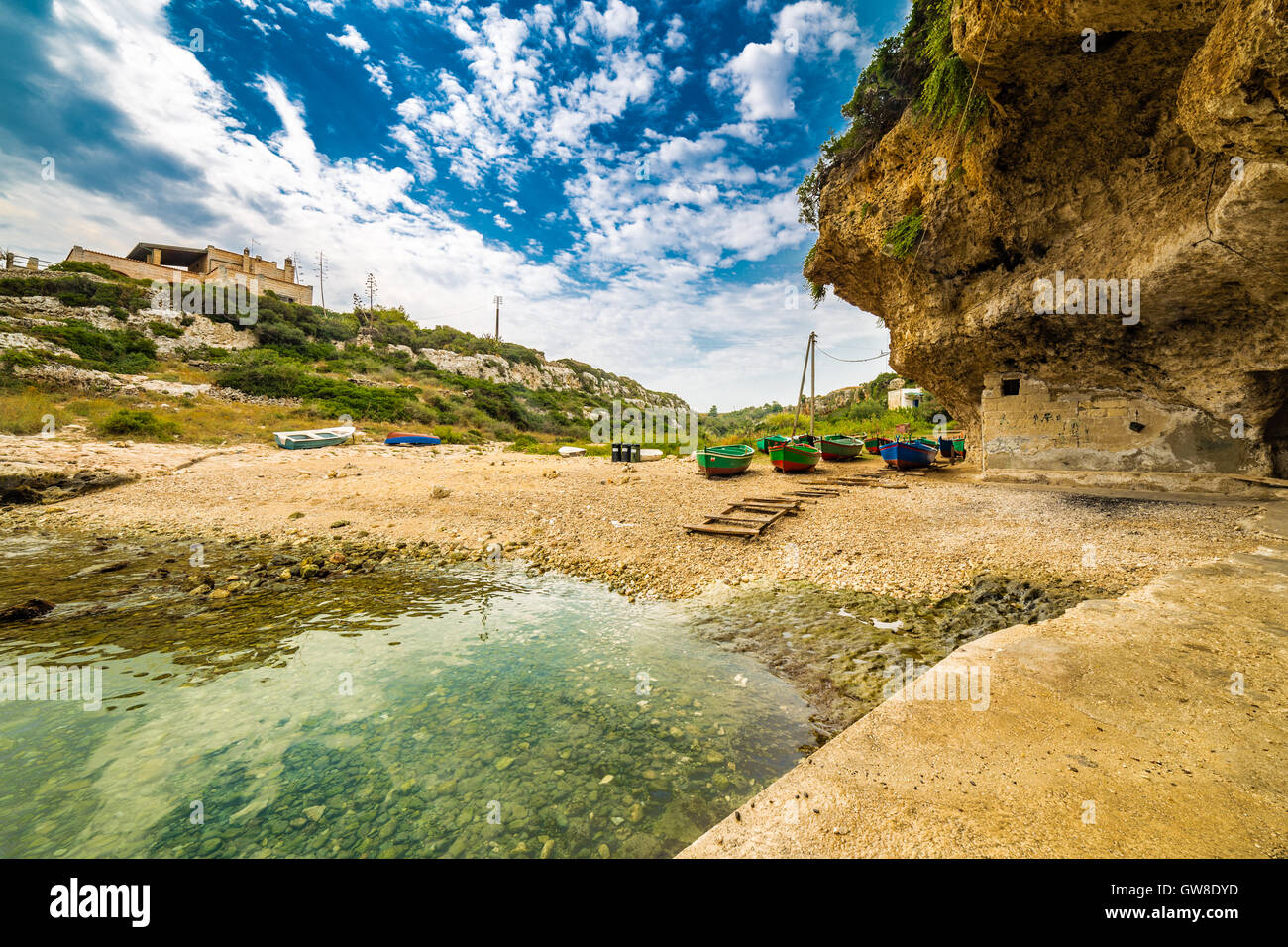 Colorate barche a remi arenarsi su una baia della costa della Puglia in Italia meridionale Foto Stock